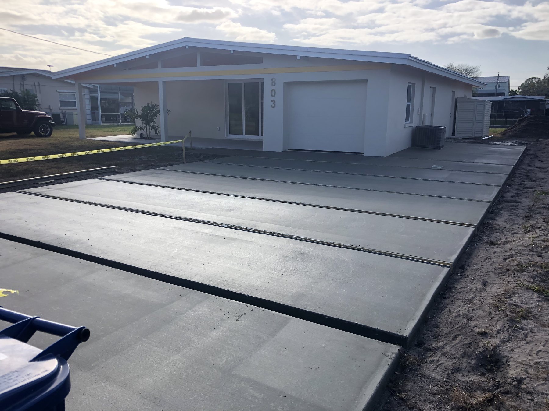 Finished paneled driveway in front of a white modern home