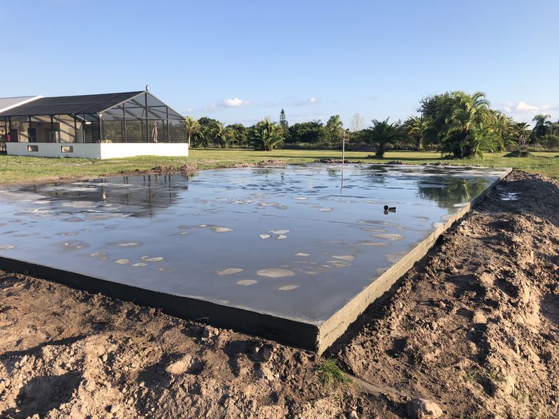 Freshly finished house slab beside a screened lanai